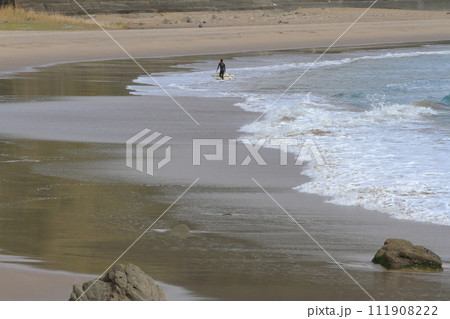 恋ヶ浦サーフポイントで海からあがるサーファーの姿 111908222