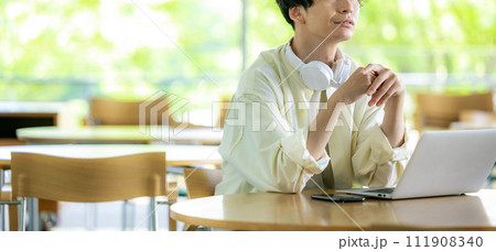 男性がカフェでパソコンを開いて作業をしている 111908340