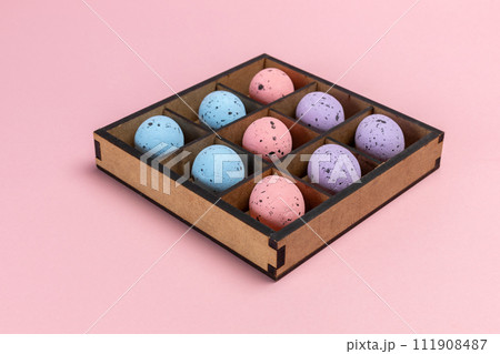 Colorful Easter eggs in a box on the pink background Colorful Easter eggs in a box on the pink background 111908487