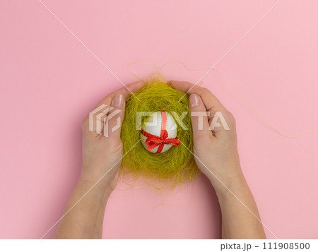 Easter egg with a red ribbon in a nest. Easter egg with a red ribbon in a nest. 111908500