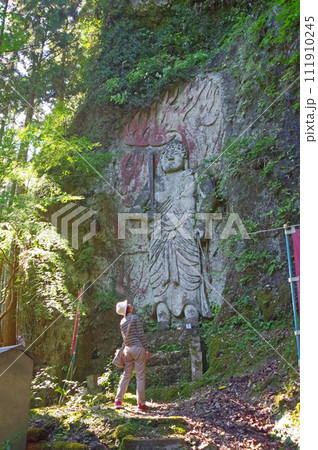 福岡県築上町の山間にある寒田摩崖仏不動明王を見上げる人物 111910245
