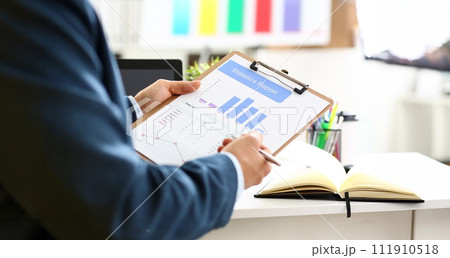 Male arm in suit show stats graphic clipped to pad 111910518