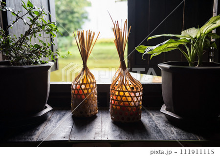 Rattan weave basket with candy by window at wood Thai house Rattan weave basket with candy by window at wood Thai house 111911115