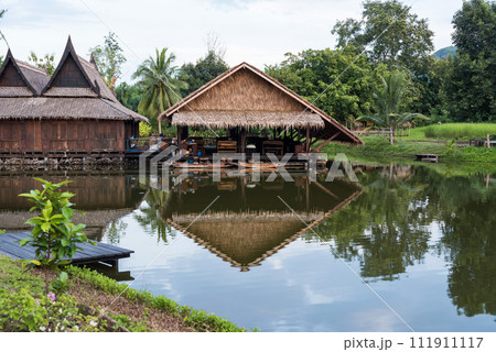 Traditional wooden thai house by canal with wood boat Traditional wooden thai house by canal with wood boat 111911117