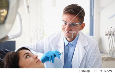 A woman at the reception of a male dentist examining 111913729