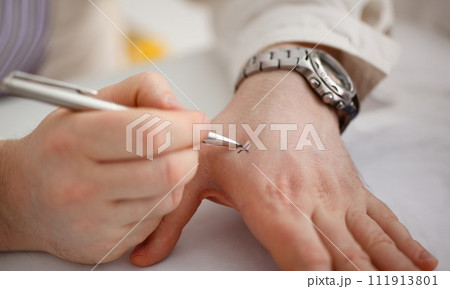 Male make x cross note with silver pen at his arm 111913801