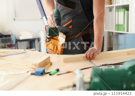 Arms of worker using electric drill Arms of worker using electric drill 111914422