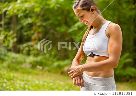 Well trained woman using fitness smart watch device under workout 111915381