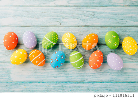 Easter Day Concept. Top view holiday banner background web design white colorful easter eggs painted on blue wood background with empty copy space, celebration greeting card, overhead, template 111916311
