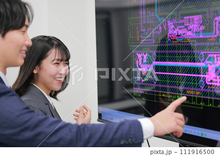 CAD画面を見ながら打ち合わせるエンジニア男女_4 111916500