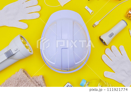 黄色背景の上のヘルメットと防災グッズ 111921774