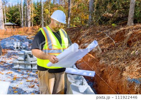 Study by construction workers shows that blueprint plans were used when installing retaining walls made of cement blocks Study by construction workers shows that blueprint plans were used when installing retaining walls made of cement blocks 111922446