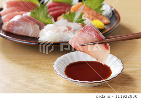 美味しそうなぶりの刺身を箸で持ち上げる 111922930