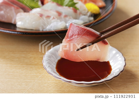 美味しそうなぶりの刺身を箸で持ち上げる 111922931