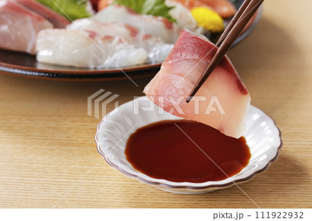 美味しそうなぶりの刺身を箸で持ち上げる 111922932