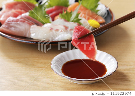 美味しそうなマグロの刺身を箸で持ち上げる 美味しそうなマグロの刺身を箸で持ち上げる 111922974