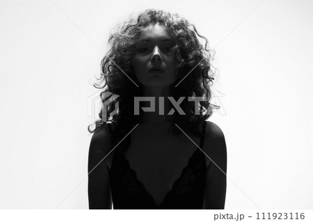 curly Hair Girl silhouette. Beautiful young Woman in white studio curly Hair Girl silhouette. Beautiful young Woman in white studio 111923116