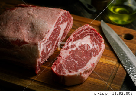 chunk of ribeye steak on wooden board chunk of ribeye steak on wooden board 111923803