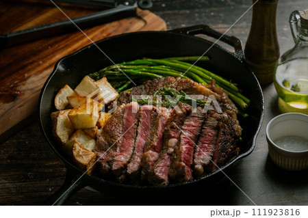 sliced ribeye steak in iron cast skillet pan sliced ribeye steak in iron cast skillet pan 111923816