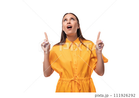 well-groomed slender young brunette lady is dressed in a bright yellow dress with short sleeves 111926292
