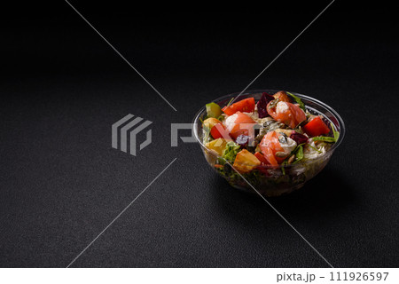 Delicious juicy salad with salmon, tomatoes, cucumber, herbs, pumpkin seeds, salt and spices 111926597