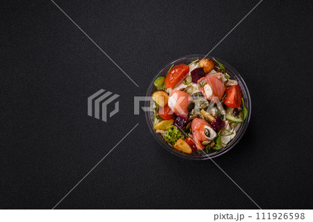 Delicious juicy salad with salmon, tomatoes, cucumber, herbs, pumpkin seeds, salt and spices 111926598