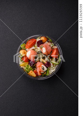 Delicious juicy salad with salmon, tomatoes, cucumber, herbs, pumpkin seeds, salt and spices Delicious juicy salad with salmon, tomatoes, cucumber, herbs, pumpkin seeds, salt and spices 111926599
