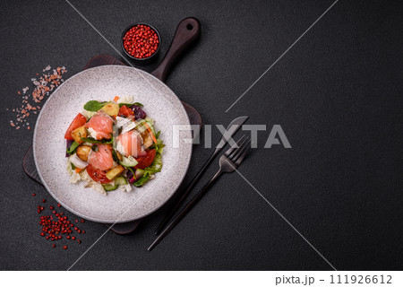 Delicious juicy salad with salmon, tomatoes, cucumber, herbs, pumpkin seeds, salt and spices 111926612