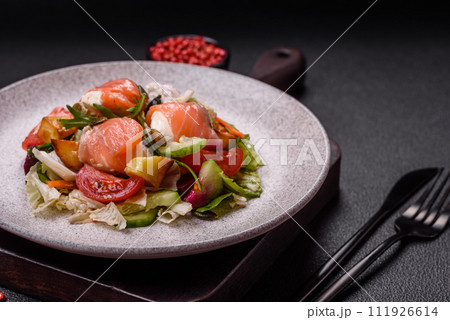 Delicious juicy salad with salmon, tomatoes, cucumber, herbs, pumpkin seeds, salt and spices 111926614