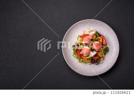 Delicious juicy salad with salmon, tomatoes, cucumber, herbs, pumpkin seeds, salt and spices 111926621
