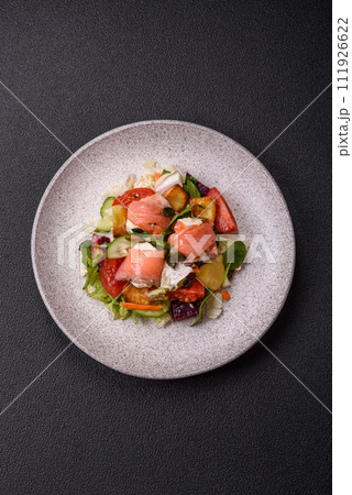 Delicious juicy salad with salmon, tomatoes, cucumber, herbs, pumpkin seeds, salt and spices Delicious juicy salad with salmon, tomatoes, cucumber, herbs, pumpkin seeds, salt and spices 111926622