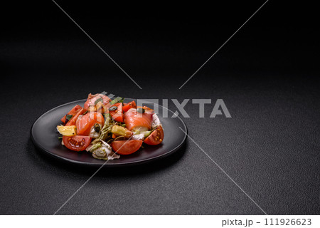 Delicious juicy salad with salmon, tomatoes, cucumber, herbs, pumpkin seeds, salt and spices Delicious juicy salad with salmon, tomatoes, cucumber, herbs, pumpkin seeds, salt and spices 111926623