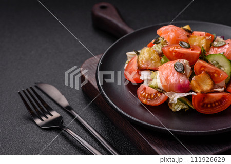 Delicious juicy salad with salmon, tomatoes, cucumber, herbs, pumpkin seeds, salt and spices 111926629