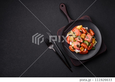 Delicious juicy salad with salmon, tomatoes, cucumber, herbs, pumpkin seeds, salt and spices 111926633