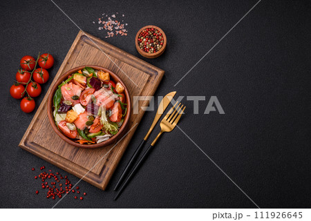 Delicious juicy salad with salmon, tomatoes, cucumber, herbs, pumpkin seeds, salt and spices 111926645