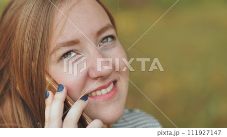 A young girl talking on the phone. Close-up of her face. A young girl talking on the phone. Close-up of her face. 111927147