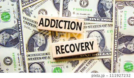 Addiction recovery symbol. Concept words Addiction recovery on beautiful wooden blocks. Dollar bills. Beautiful background from dollar bills. Psychology addiction recovery concept. Copy space. 111927232