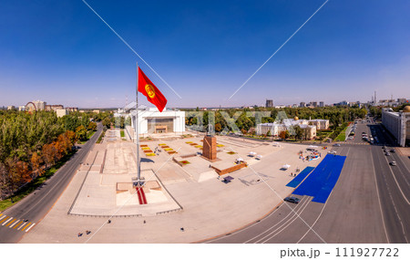 Aerial top view to Flag Kyrgyzstan. Monument Epic Statue of Aykol Manas - kyrgyz hero on Ala-Too Square. State History Museum in downtown of Bishkek city. Central asia, Aerial top view to Flag Kyrgyzstan. Monument Epic Statue of Aykol Manas - kyrgyz hero on Ala-Too Square. State History Museum in downtown of Bishkek city. Central asia, 111927722