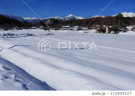 雪に覆われた畑と山 雪に覆われた畑と山 111934227