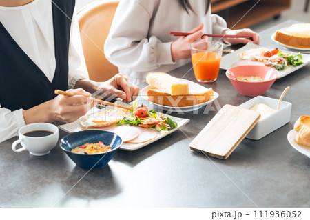 ダイニングで食事する親子 111936052
