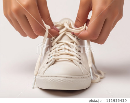 The Process of Tying Shoelaces for Starting a New Day on white background. 111936439