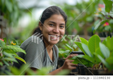 Smiling female agriculture worker using digital tablet at plant nursery, 111940130
