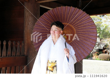 丈が長めの羽織が洒落たシルバーと白の男袴、紋付袴姿の成人男性、成人式ロケーション撮影 111941620