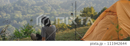 landscape and travel concept with solo freelancer man relax and play with cat and see sunset with layer of mountain 111942644