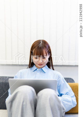 ノートパソコンで仕事をする/リモートワークをする女性 ノートパソコンで仕事をする/リモートワークをする女性 111942998