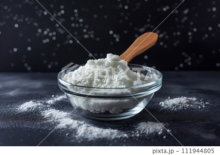 Hydrolyzed collagen powder in a glass bowl with wooden spoon on a black background Hydrolyzed collagen powder in a glass bowl with wooden spoon on a black background 111944805