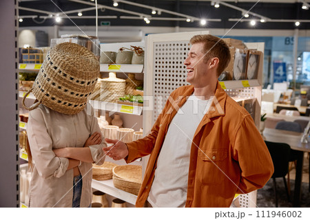 Depressed woman customer standing with wicker basket on head 111946002