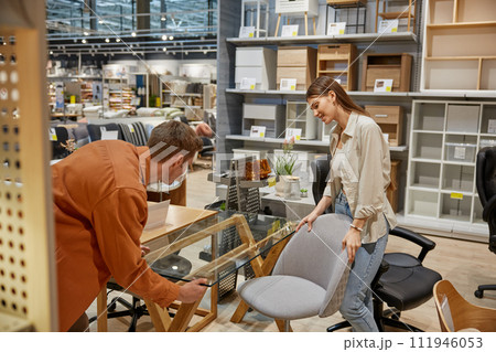 Young couple choosing furniture for dining room at modern shop department 111946053