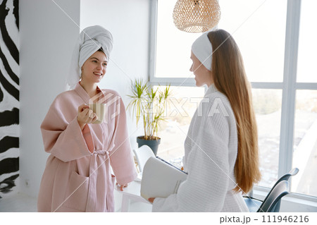 Portrait of two positive girl friends talking together in morning 111946216