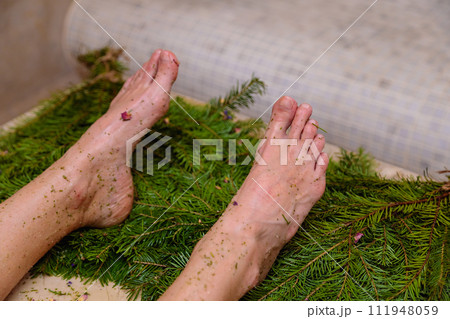 Feet of a woman in a hammam on spruce brooms Feet of a woman in a hammam on spruce brooms 111948059